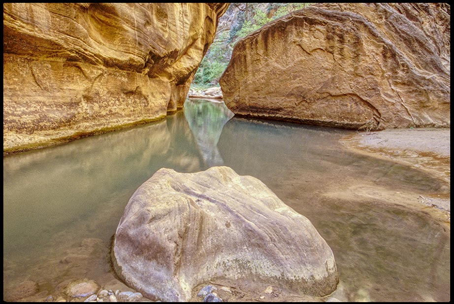 The waters of the Virgin River flow a around a rock in the middle of the Narrows, Zion National Park, Utah and Isaiah 32:2. A refreshing steam in a dry country. 