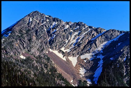A pointed peak in the Bob Marshall wilderness against blue sky