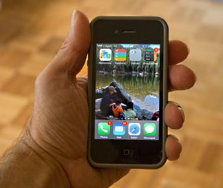 An iphone 4s with a photo of a mon and kids at Bear Lake in Rocky Mountain National Park
