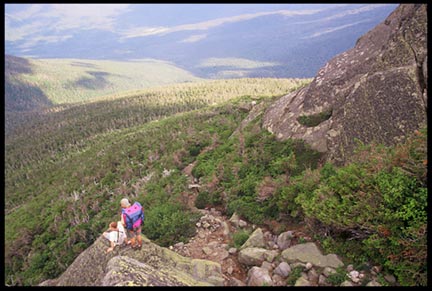 Two hikers on a rock over looking the Great Gulf Wilderness in the White Mountains of New Hampshire