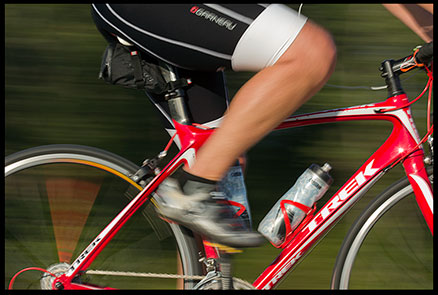 Blurred panning shot of cyclist legs peddling on a bike along the Keystone Trail, Nebraska 