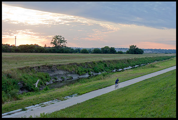 A lone cyclist riding a bike a sunset on the Keystone Trail, Nebraska