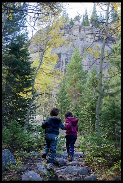 A little boy and girl hike a fall path near the Mills Lake Trail, Rocky Mountain National Park, Colorado and Matthew 18:3-4 Bible verse become like children