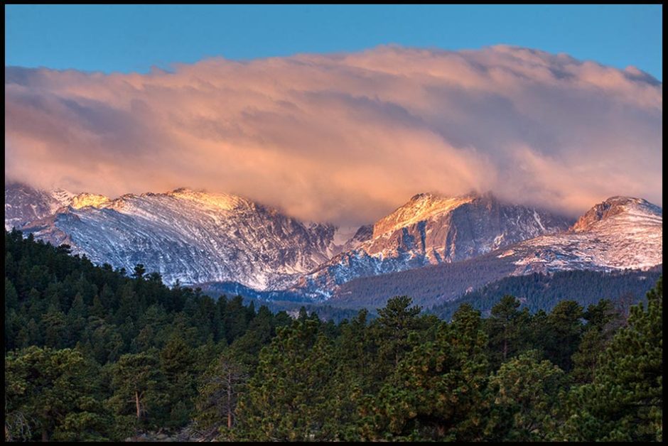 Mountains covered in clouds at Sunrise in Rocky Mountain National Park and Bible verse Psalm 111:3 about a Splendid and majestic God