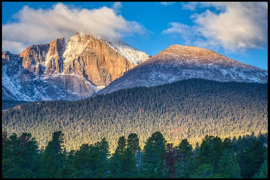 Sunlight breaking through clouds to light up, Longs Peak in Rocky Mountain National Park in Colorado. Bible verse of the day Luke 2, and Angels We have heard on High.