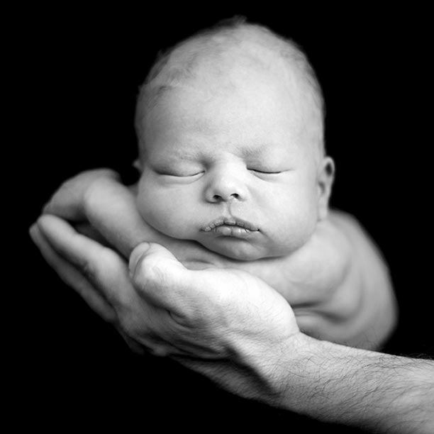 A small child held in One Hand in black and white photo. Bible verse of the day fearfully and wonderfully made. Psalm 139:13-15a