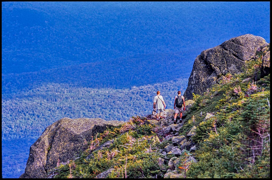 Two hikers Pass two large boulders as they head towards the Great Gulf, White Mountains, New Hampshire. Bible verse of the day, Deuteronomy 1:21 Take possession
