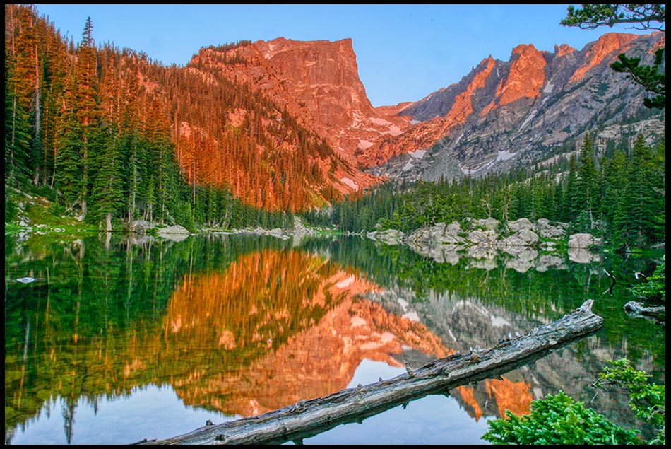 The alpine glow of the sunrise hits Hallett Peak and Flattop Mountain reflecting in Dream Lake, Rocky Mountain National Park, Colorado. Bible Verse of the Day: Isaiah 44:23, "Sing for joy, you heavens
