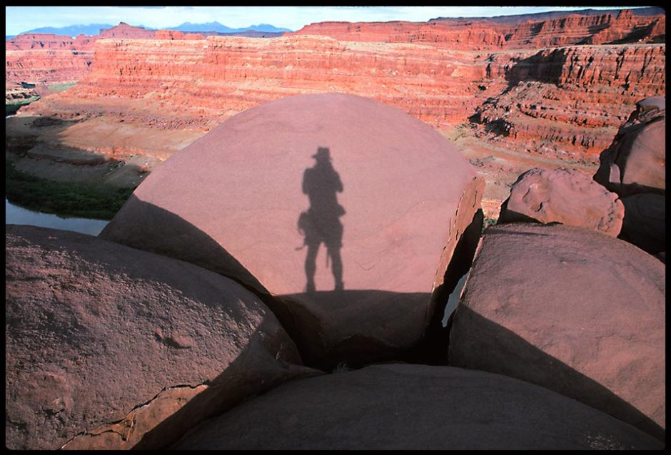 A photographers shadow on rounded boulders, Canyon Lands National Park, Utah and Bible verse Psalms 102:11-12 Fade lake a shadow
