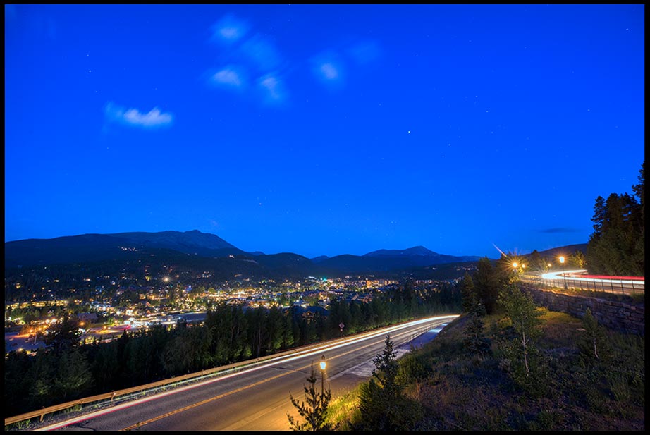 The mountain town of Breckenridge, Colorado under a clear nighttime sky with car headlight trails as seen from Ski Hill Road. Bible Verse of the Day Isaiah 42:16