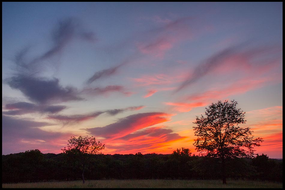 A red and blue sunset sky with clouds, Mahoney State Park, Nebraska and Bible verse Psalm 104:2-3. "The Lord wraps light