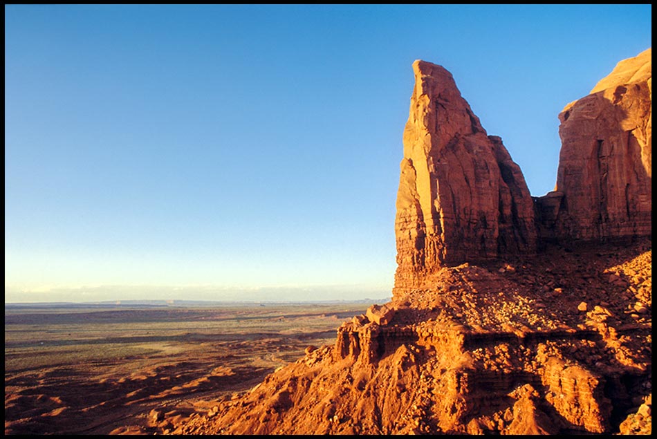 A desert red rock spire reaching into a blue sky, Monument Valley, Utah. Bible Verse of the Day: Psalm 33:11: the LORD stands forever