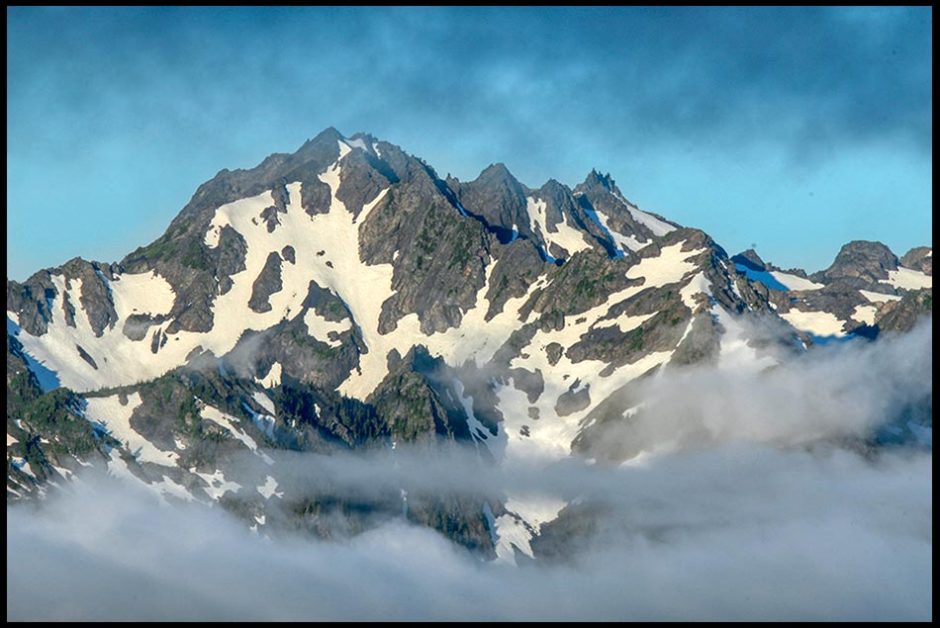 Mount Carrie of the Olympic Range between layers of clouds, Olympic National Park, Washington State Mountains and the confidence of God