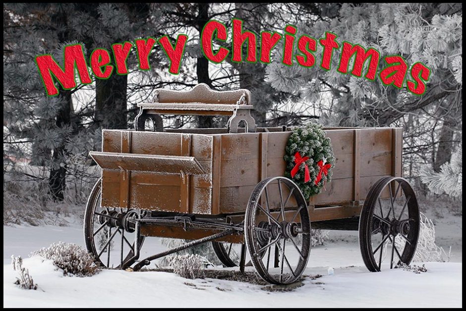 An old fashion wooden pioneer wagon in the snow with the words merry Christmas in red, Sarpy County Nebraska. Joy to the world Bible verse of the day Luke 2:11