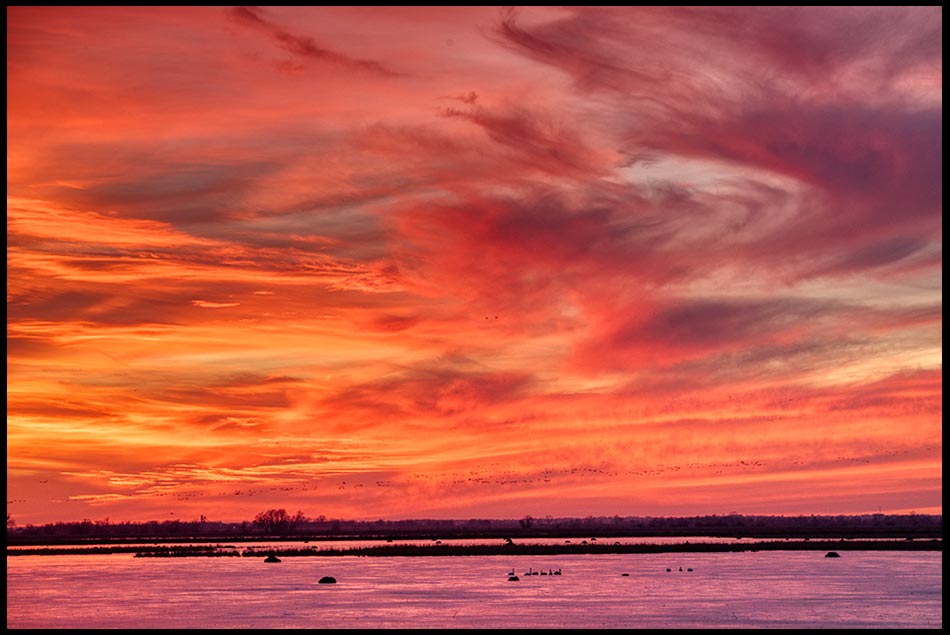 Red sunset sky with whispy clouds over the lake at Loess Bluffs Wildlife Refuge National Wildlife Refuge, Missouri. Bible Verse of the Day: Psalm 57:10-11