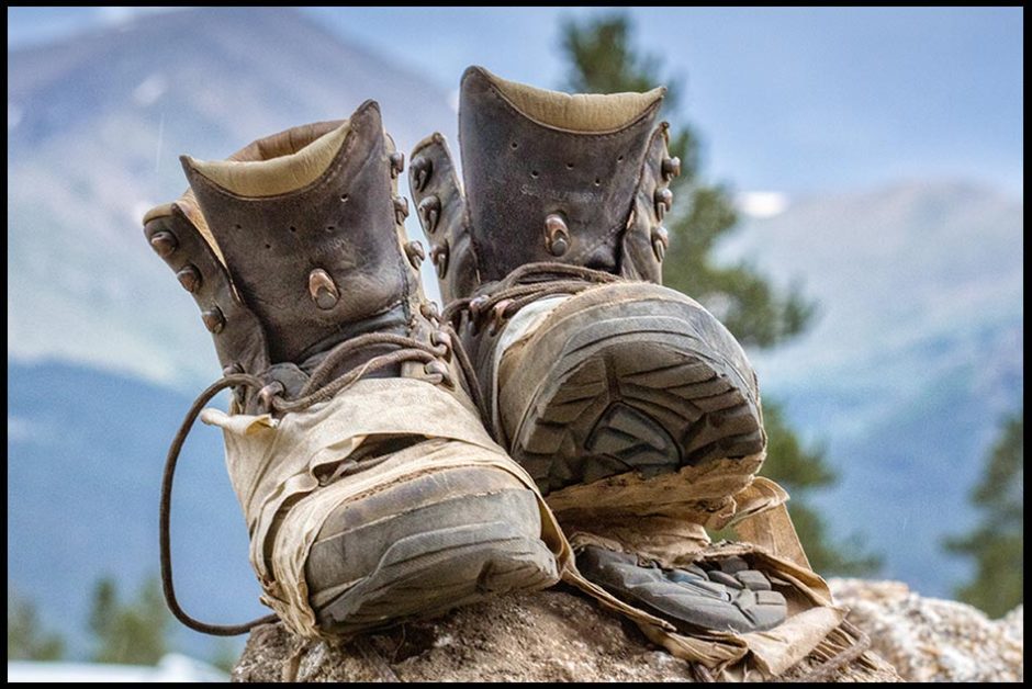 A pair of old worn out hiking boots on a rock with Mount Elbert in Colorado in the background. Bible verse of the day Deuteronomy 29:5, Forty years of faithfulness