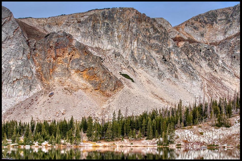 A tight photograph of part of the snowy mountain range above mirror Lake in Wyoming. Bible verse of the day Isaiah 4:9 mountain tops