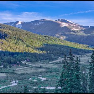 A dirt road and houses look tiny in mountain valley in the San Isabel National Forest, Colorado. Bible Verse of the Day: Jeremiah 33, God says, Call to Me.